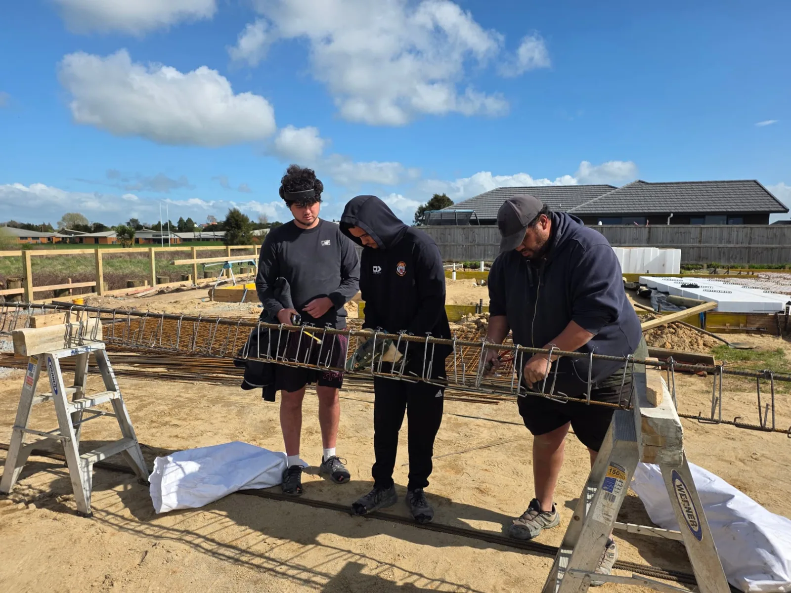 Walter, Bailey and Teohonga tying reinforcing steel on site